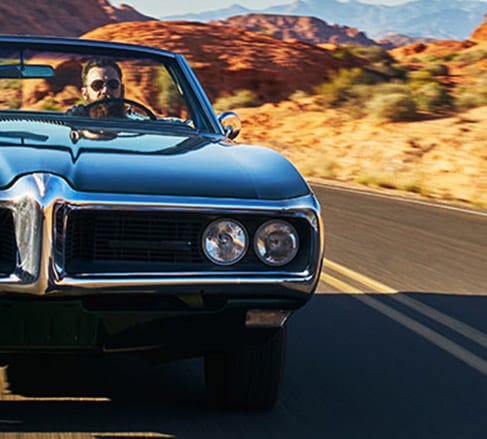 image of a man driving a classic car happy his car is insured by the best hobby car insurance in {location}